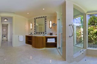 A modern bathroom with a glass-enclosed shower, a vanity with a mirror, and a toilet.