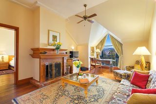 A spacious living room with a fireplace, a coffee table, a sofa, and a view of the outdoors.