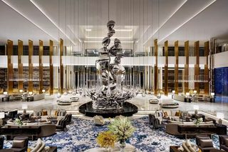 A spacious lobby with a central fountain, seating areas, and a modern design.