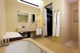 A modern bathroom with a large bathtub, a vanity with a mirror, and a shower area.