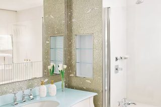 A bathroom with a white sink, a large mirror, and a shower.