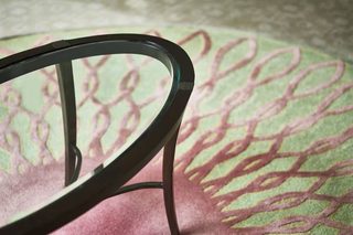 A chair with a curved metal frame and a patterned cushion.