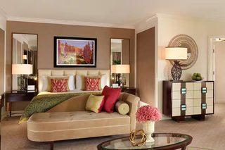 A well-appointed living room with a sofa, a glass coffee table, and a decorative mirror.