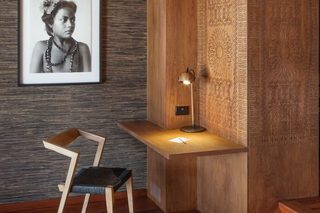 A modern room with a wooden desk, a framed photograph on the wall, and a chair.